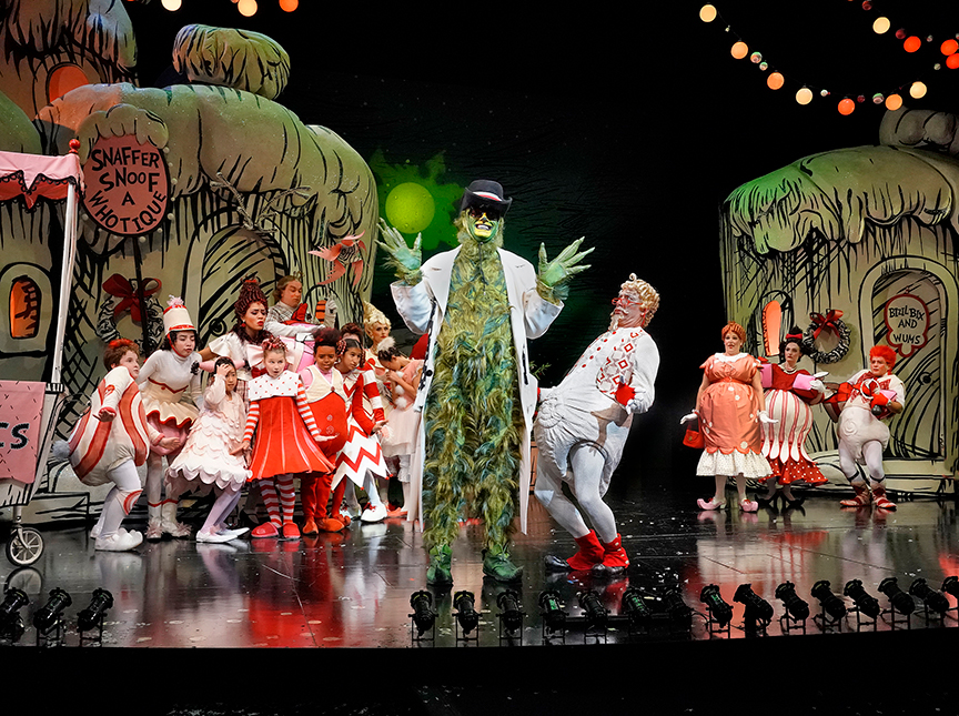 (center) Edward Watts appears as The Grinch with the cast of Dr. Seuss's How the Grinch Stole Christmas!, book and lyrics by Timothy Mason, music by Mel Marvin, original production conceived and directed by Jack O'Brien, original choreography by John DeLuca, and directed by James Vásquez, running November 3 – December 29, 2018 at The Old Globe. Photo by Ken Howard.