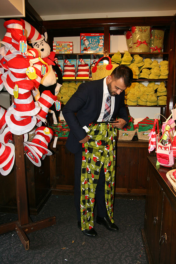 Shopper Nasim Abbas Sharifi trying on the super soft Grinch pijamas sold at the Helen Edison Gift Shop.