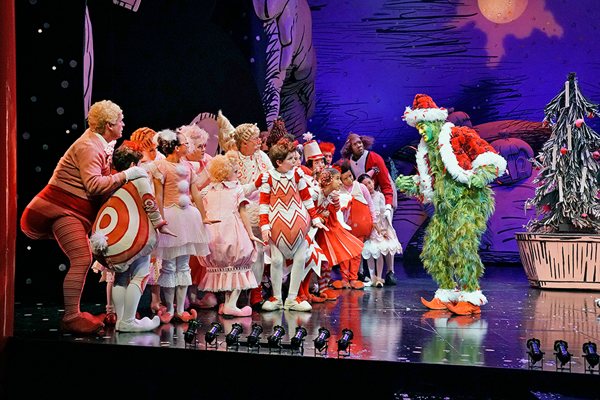(far right) Edward Watts appears as The Grinch with the cast of Dr. Seuss's How the Grinch Stole Christmas!, book and lyrics by Timothy Mason, music by Mel Marvin, original production conceived and directed by Jack O'Brien, original choreography by John DeLuca, and directed by James Vásquez, running November 3 – December 29, 2018 at The Old Globe. Photo by Ken Howard.