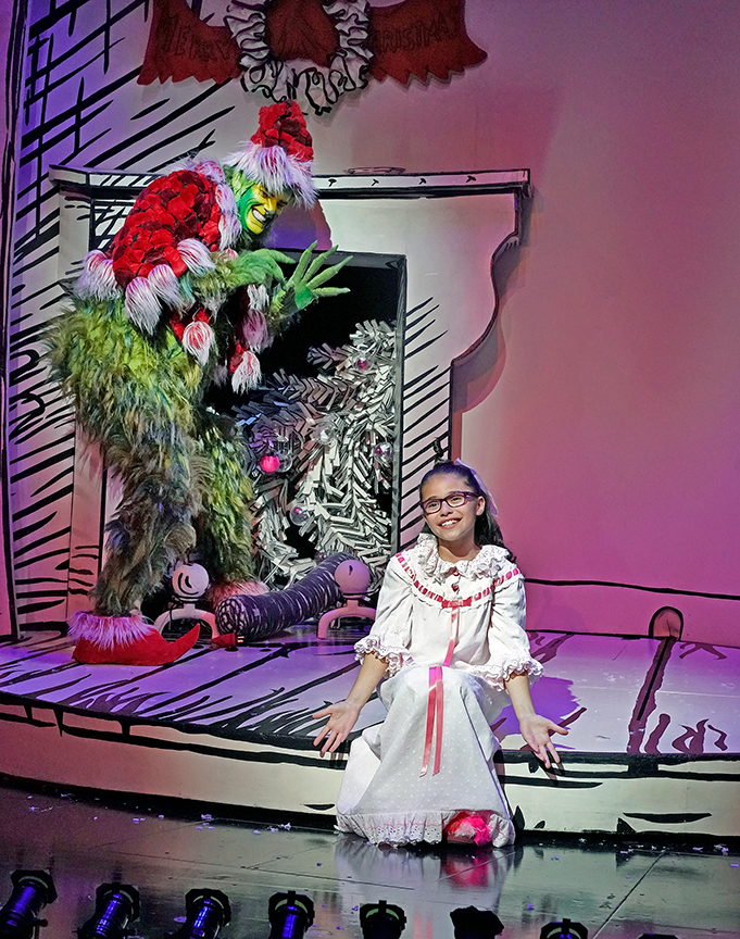 Edward Watts appears as The Grinch and Sadie Tess Coleman as Cindy-Lou Who in Dr. Seuss's How the Grinch Stole Christmas!, book and lyrics by Timothy Mason, music by Mel Marvin, original production conceived and directed by Jack O'Brien, original choreography by John DeLuca, and directed by James Vásquez, running November 3 – December 29, 2018 at The Old Globe. Photo by Ken Howard.